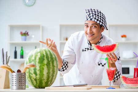 Male cook with watermelon in kitchenの写真素材