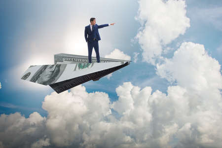 Businessman flying on paper plane in business conceptの写真素材