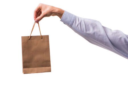Hand holding shopping bags with christmas shopping on white backgroundの写真素材