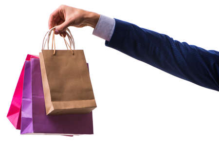 Hand holding shopping bags with christmas shopping on white background