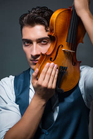 Young musician man practicing playing violin at homeの写真素材