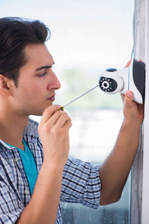 Man installing surveillance CCTV cameras at home