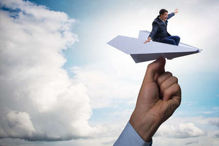 Businessman flying on paper plane in business conceptの写真素材