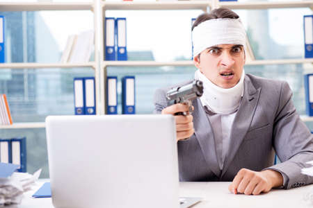 Injured businessman working in the officeの写真素材