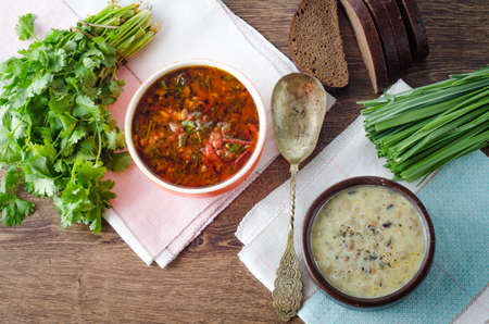 Borsch and mushroom soup served on table