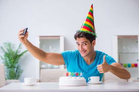 Young man celebrating birthday alone at homeの写真素材
