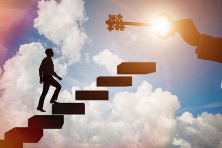 Businessman with key and jigsaw puzzle piecesの写真素材