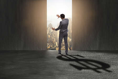 Businessman casting dollar shape shadow in business conceptの写真素材