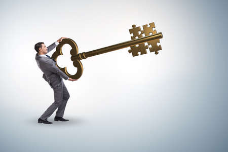 Businessman with key and jigsaw puzzle piecesの写真素材