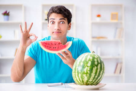 Man eating watermelon at homeの写真素材