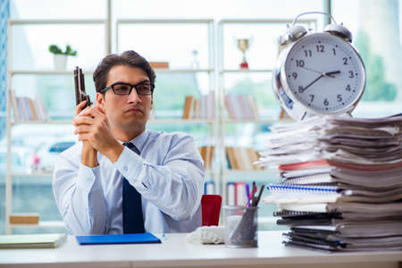 Angry businessman with gun thinking of committing suicideの写真素材