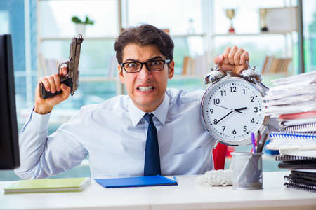 Angry businessman with gun thinking of committing suicideの写真素材