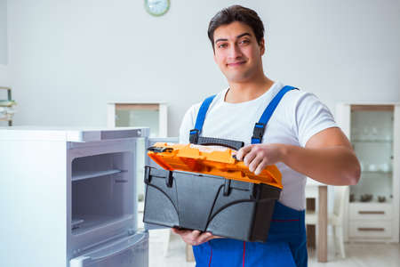 Repairman contractor repairing fridge in DIY conceptの写真素材