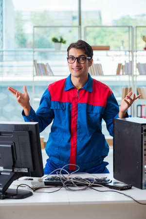 Computer repairman working on repairing computer in IT workshopの写真素材