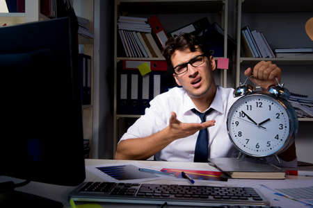 Man businessman working late hours in the officeの写真素材