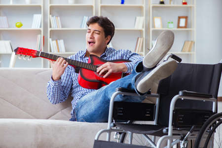 Disabled man playing guitar at homeの写真素材
