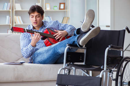 Disabled man playing guitar at homeの写真素材