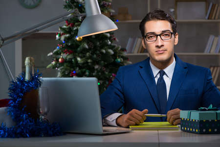 Businessman working late on christmas day in officeの写真素材