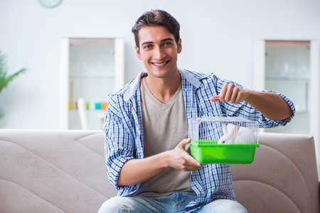 Young man playing with pet rabbit at homeの写真素材
