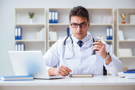Male doctor in anti-smoking conceptwithcigarette packの写真素材