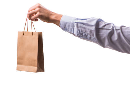 Hand holding shopping bags with christmas shopping on white backgroundの写真素材