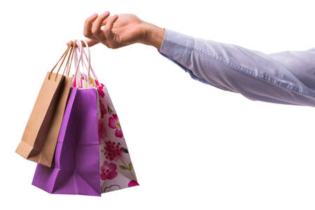 Hand holding shopping bags with christmas shopping on white backの写真素材