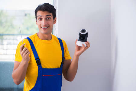 Contractor installing surveillance CCTV cameras in officeの写真素材
