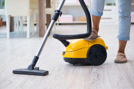 Woman doing cleaning at home with vacuum cleanerの写真素材