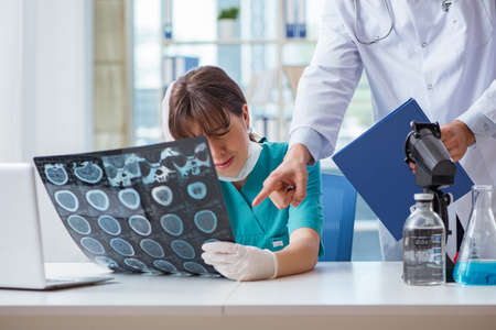 Two doctors discussing x-ray MRI image in hospitalの写真素材