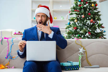 Businessman working at home during christmasの写真素材