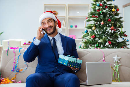 Businessman working at home during christmasの写真素材