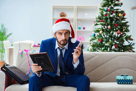 Businessman working at home during christmasの写真素材
