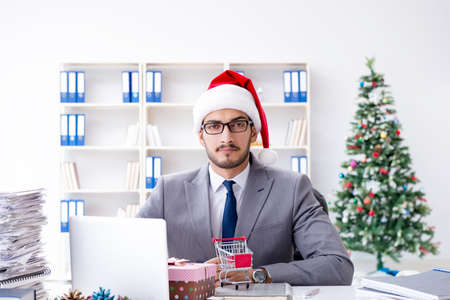 Young businessman celebrating christmas in the officeの写真素材