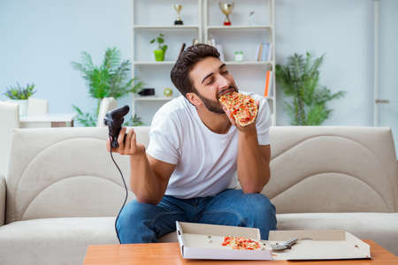 Man eating pizza having a takeaway at home relaxing restingの写真素材