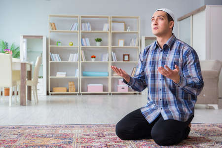 Young muslim man praying at homeの写真素材