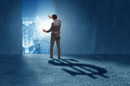 Businessman casting dollar shape shadow in business conceptの写真素材