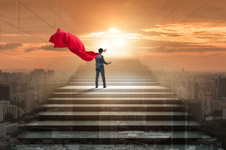 Businessman superhero pressing virtual buttons on career ladderの写真素材