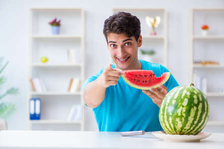 Man eating watermelon at homeの写真素材