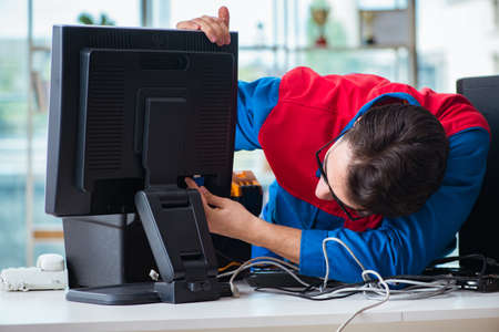 Computer repairman working on repairing computer in IT workshopの写真素材