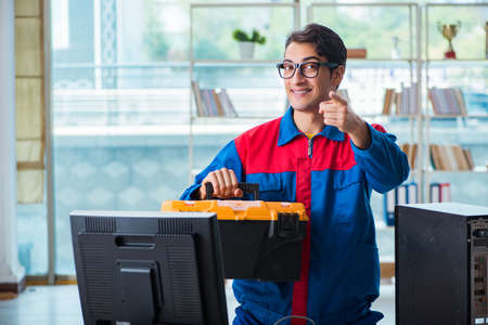 Computer repairman working on repairing computer in IT workshopの写真素材