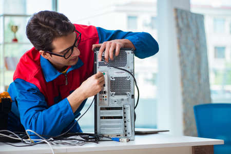 Computer repairman working on repairing computer in IT workshop