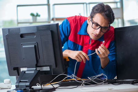 Computer repairman working on repairing computer in IT workshopの写真素材