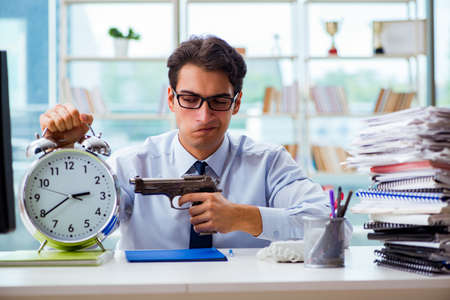 Angry businessman with gun thinking of committing suicideの写真素材