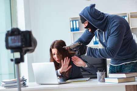Criminal recording message for ransom with victim businesswomanの写真素材