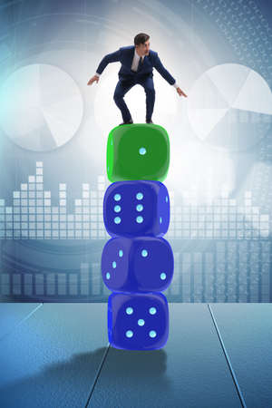 Businessman balancing on top of dice stack in uncertainty concepの写真素材