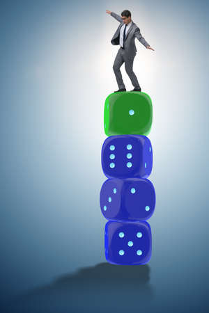 Businessman balancing on top of dice stack in uncertainty concepの写真素材