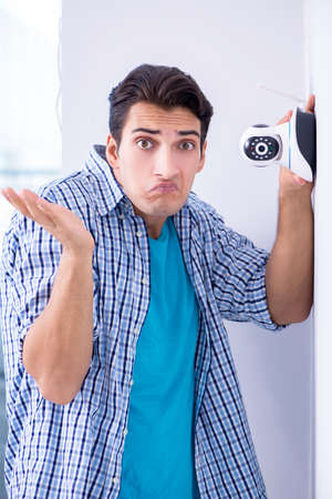Man installing surveillance CCTV cameras at homeの写真素材