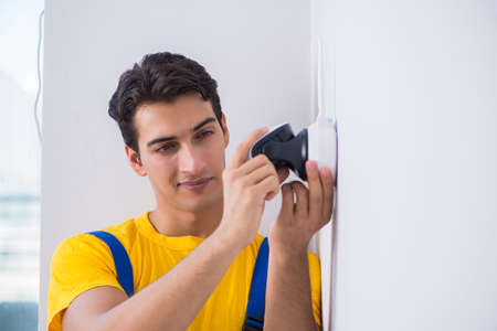 Contractor installing surveillance CCTV cameras in officeの写真素材