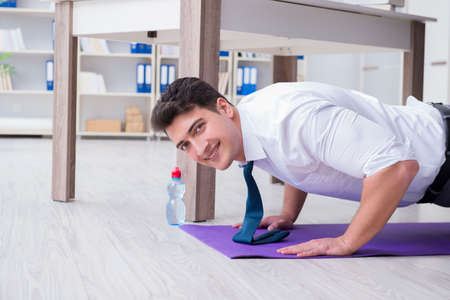 Businessman doing sports at his office space