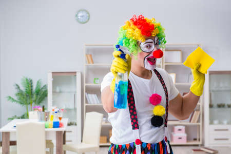 Funny clown doing cleaning at homeの写真素材